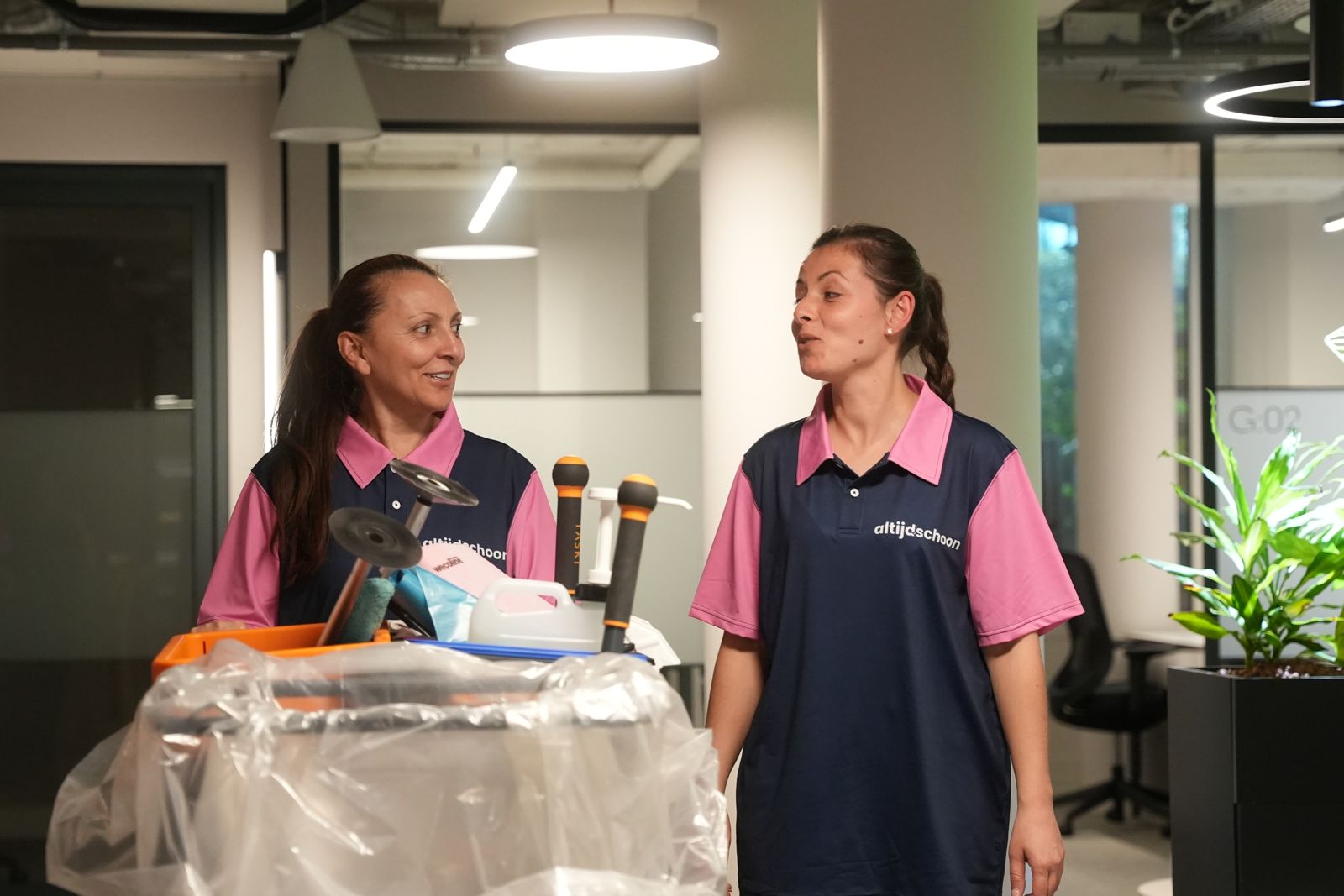 Twee medewerkers van Altijdschoon in gesprek bij de trolley